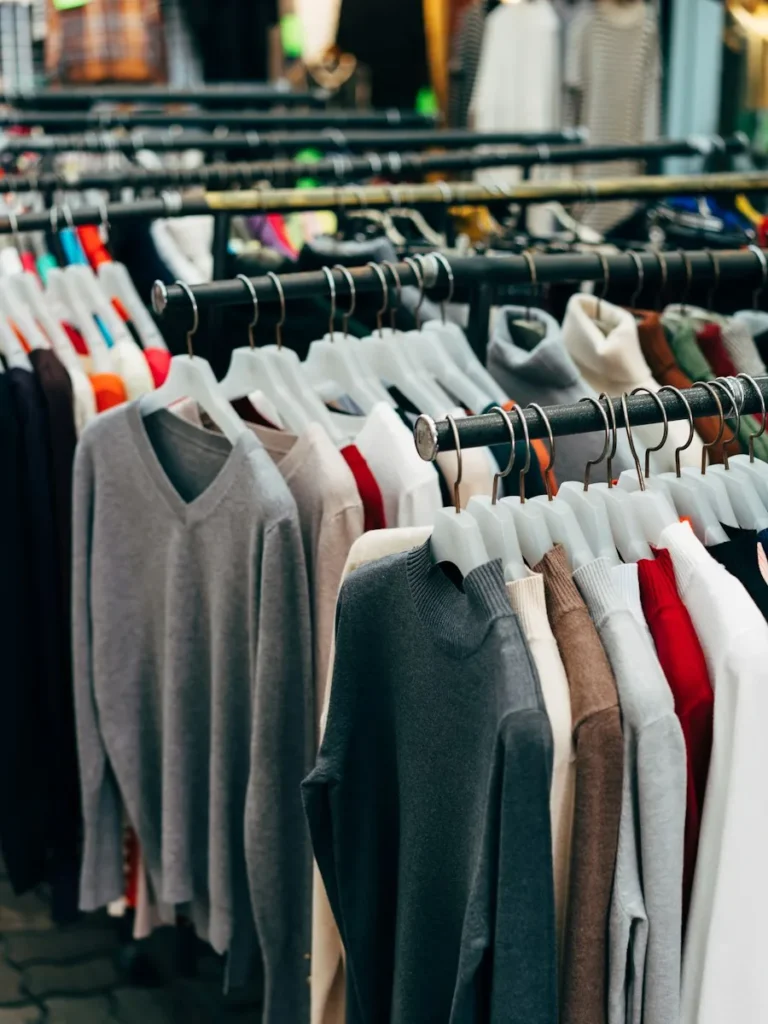 Perchero de una tienda de ropa con prendas de punto colgadas